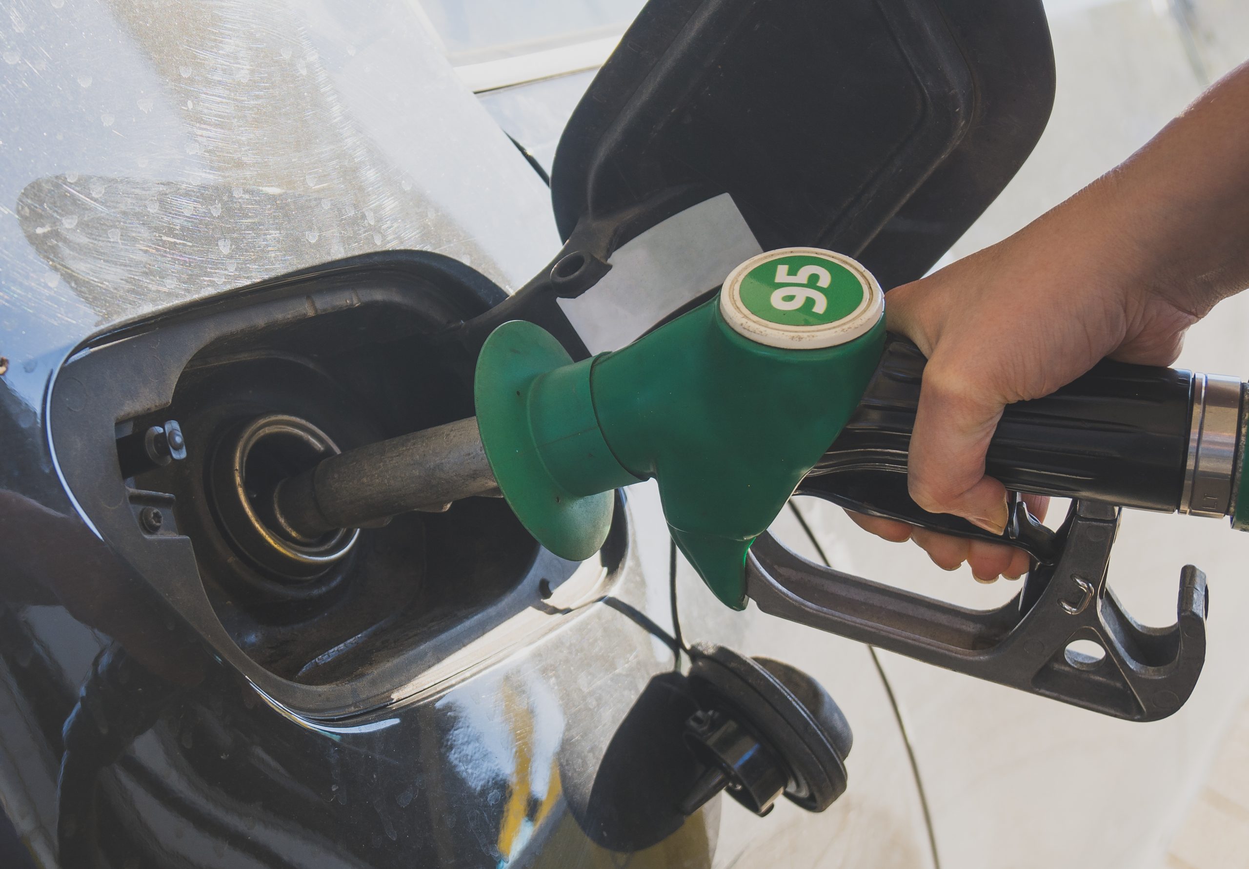 Une dame faisant le plein d'essence pour sa voiture dans une station essence