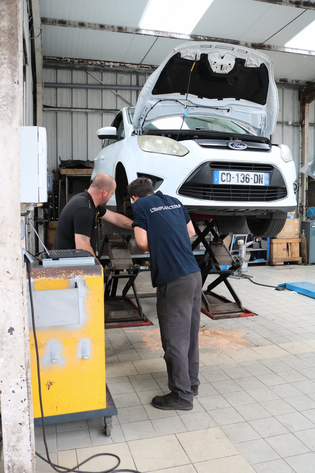 Photo d'un garage avec une voiture en cours de réparation